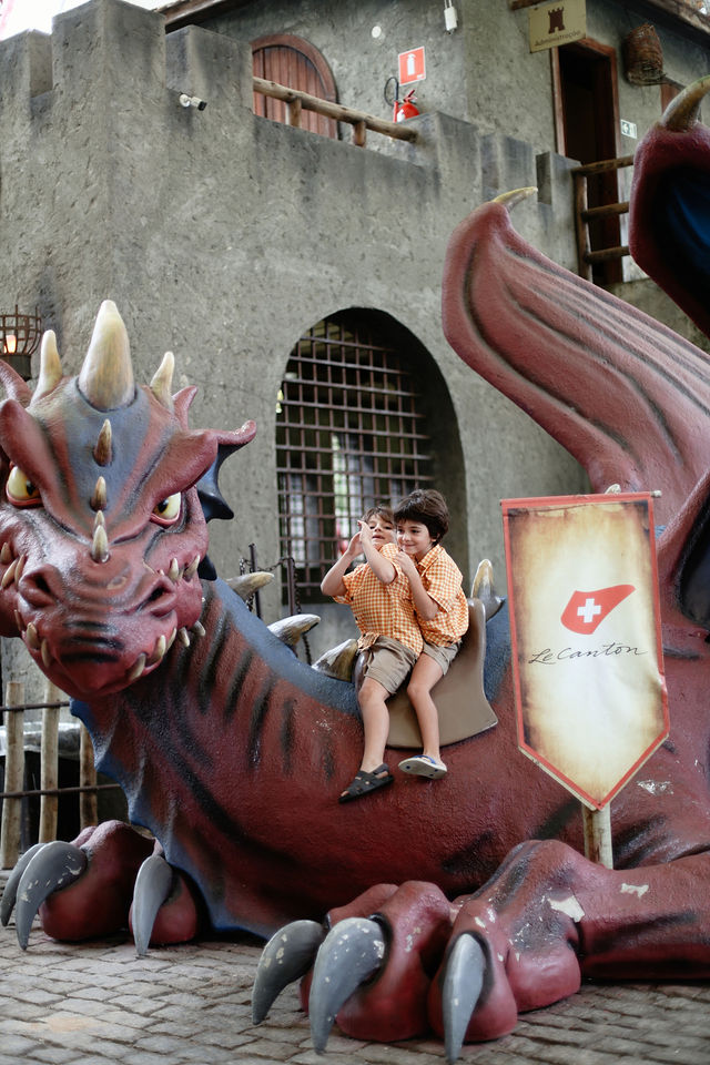 Crianças no brinquedo temático de dragão do Parc Magique